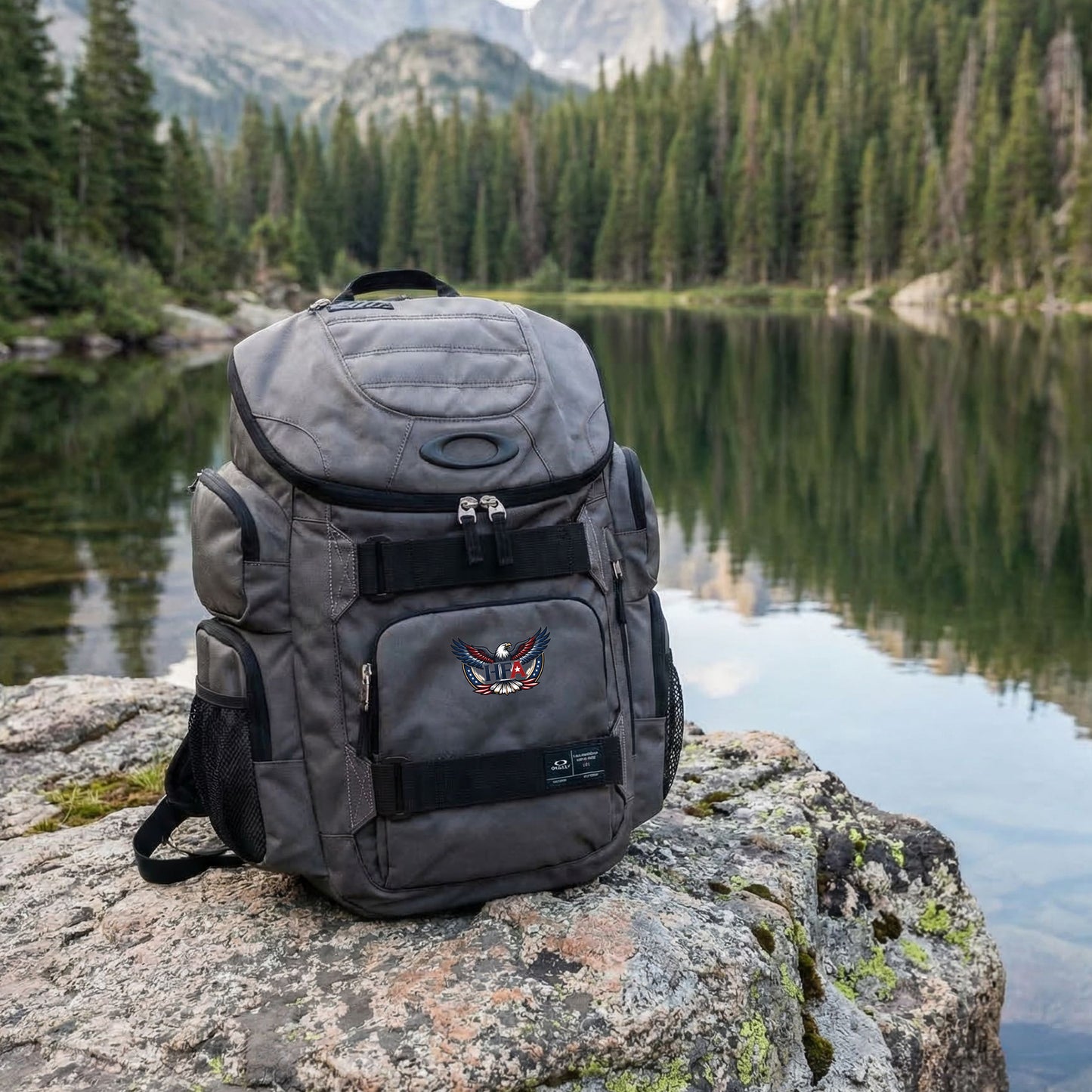 Gray backpack on a rock with a mountain and lake background